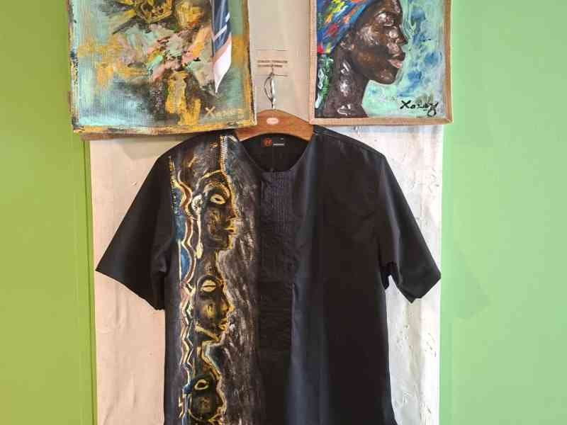 Un ensemble de sacs à main artisanaux peints et d'une chemise noire ornée de motifs artistiques de style africain, photo gratuite