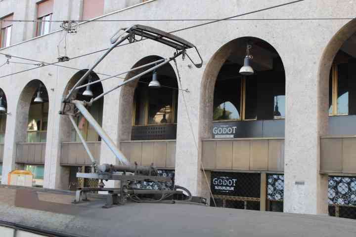 Des lignes de tramway avec un batiment, en arriere plan, le mot "GODOT" un moteur de jeux, visible sur enseignes de l'image, photo gratuite
