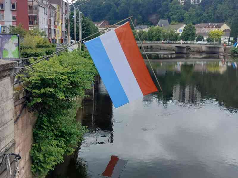 Drapeau du Luxembourg accroché à un mur au bord du lac, photo gratuite