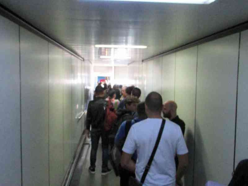 Passagers traversant une passerelle d'embarquement à bord d'un avion