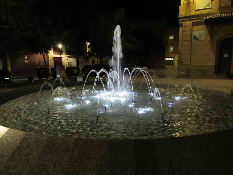 Une fontaine moderne illuminée la nuit, photo gratuite
