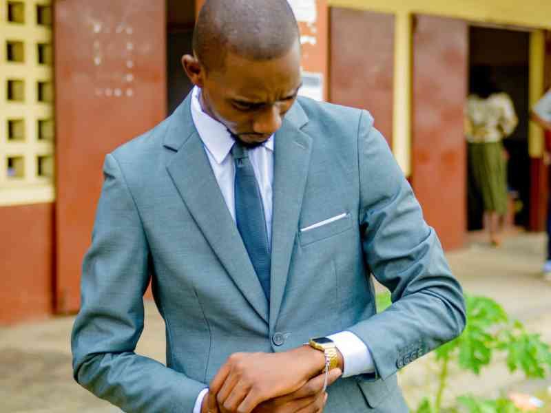 Un homme en costume vérifiant l'heure : Casteret-Danick photo gratuite