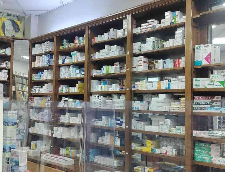 L'intérieur d'une pharmacie, avec des étagères en bois remplies de divers médicaments et produits de santé, photo gratuite
