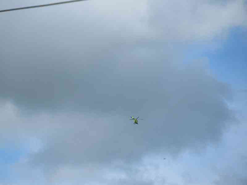Hélicoptère au dessus de nuages gris dans le ciel