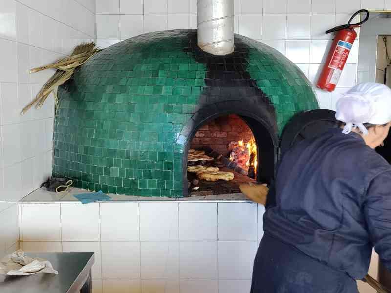 Personne préparant du pain ou de la pizza dans un grand four, photo gratuite